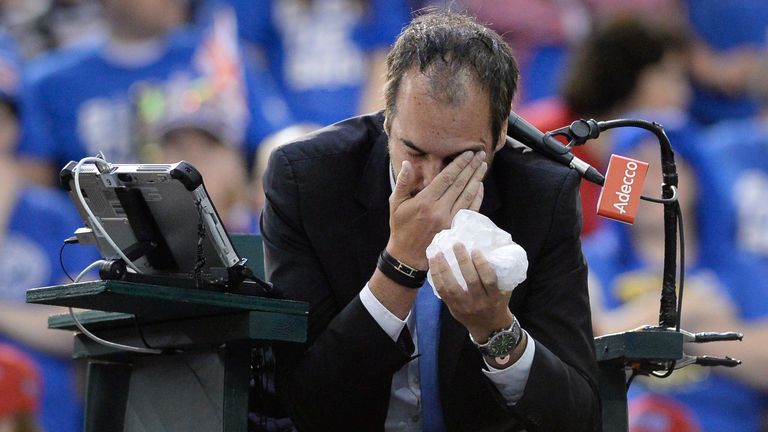 Umpire Arnaud Gabas, of France, holds his face after being hit by a ball during first-round Davis Cup tennis match action between Canada's D